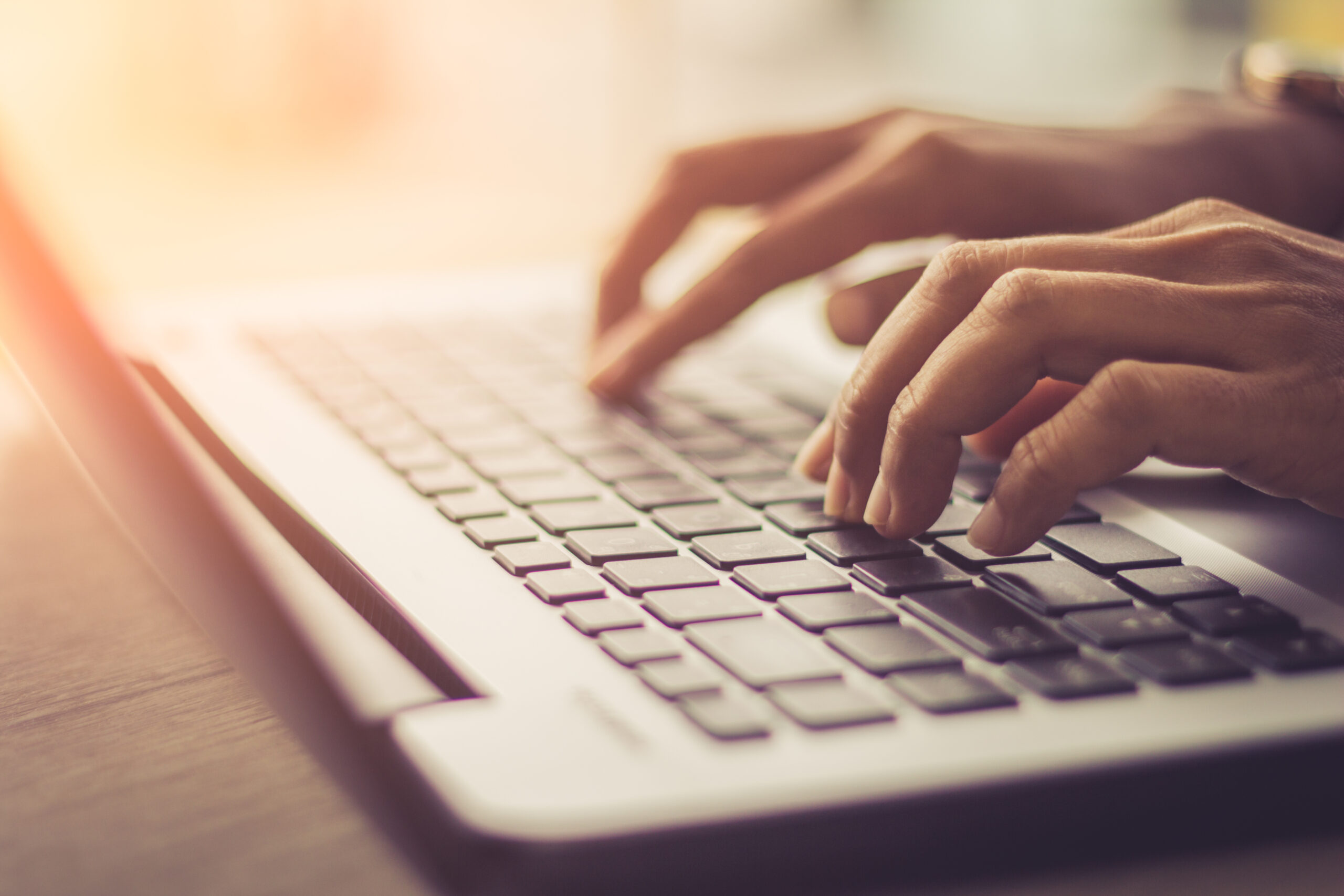 Hands typing on a laptop.
