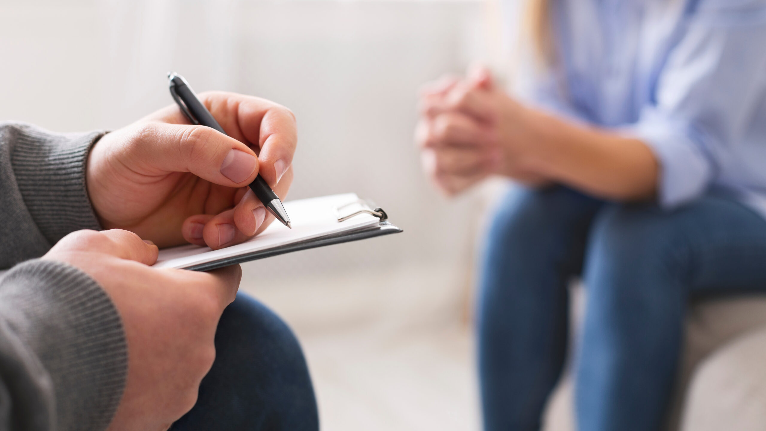 Counsellor taking notes during a patient therapy session