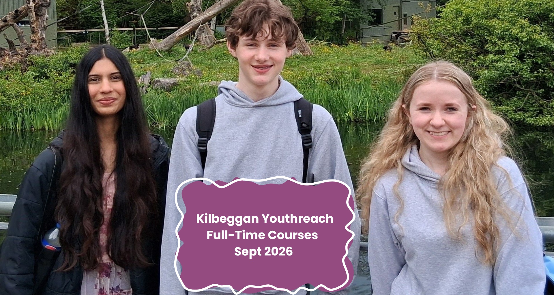 Three young people stand outdoors in front of greenery and water, with a sign reading Kilbeggan Youthreach Full-Time Courses Sept 2026.